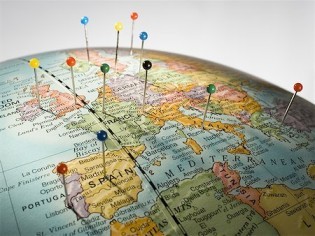 push pins pressed into destinations on globe