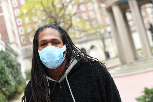 Daniel Igbokwe (CC'20) by Eileen Barroso Individual with a braid hairstyle wearing a mask and looking at camera