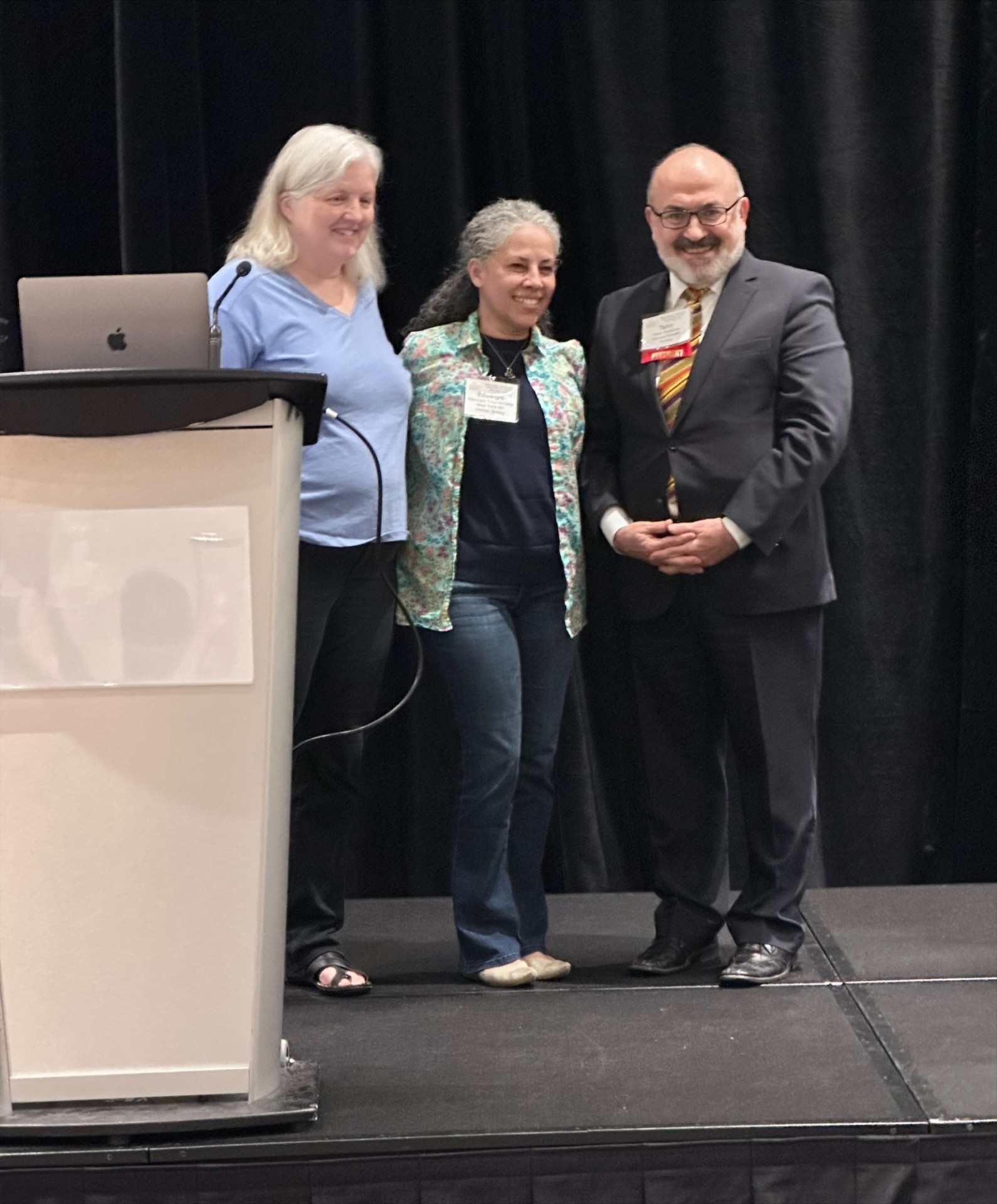 Eduvigis standing on stage in line with two people