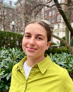 Individual with hair pulled back smiling into camera